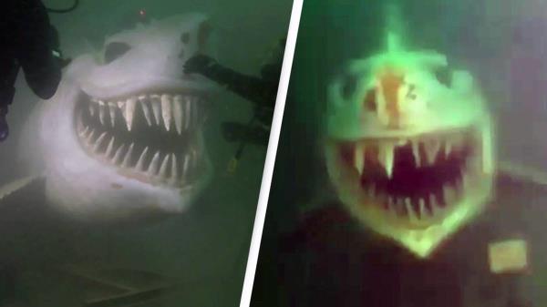 邪恶的天才隐藏在湖底巨大的鲨鱼雕像，以吓唬潜水员